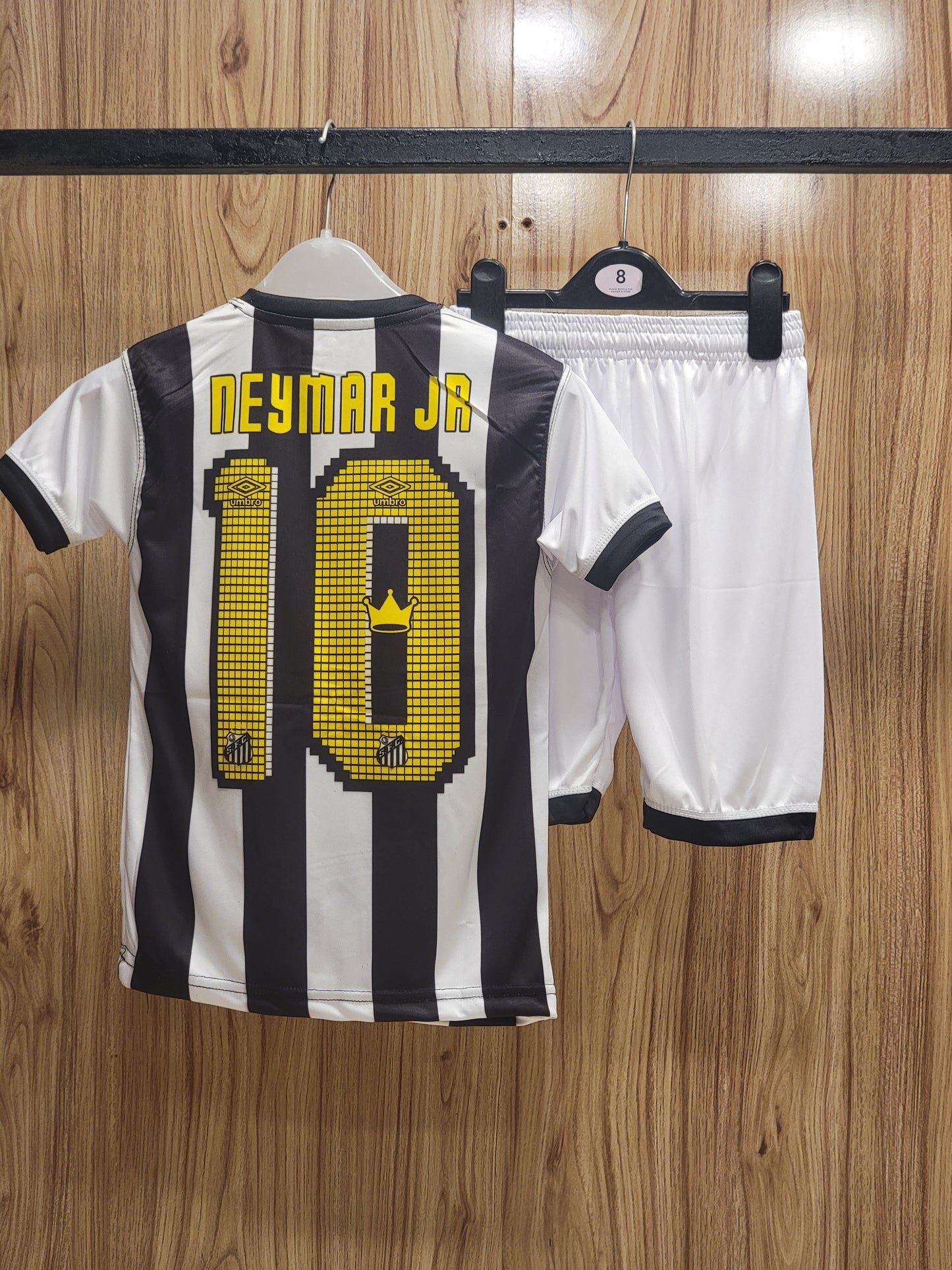Soccer jersey with number 10 and name 'NEYMAR JR.' on a wooden surface